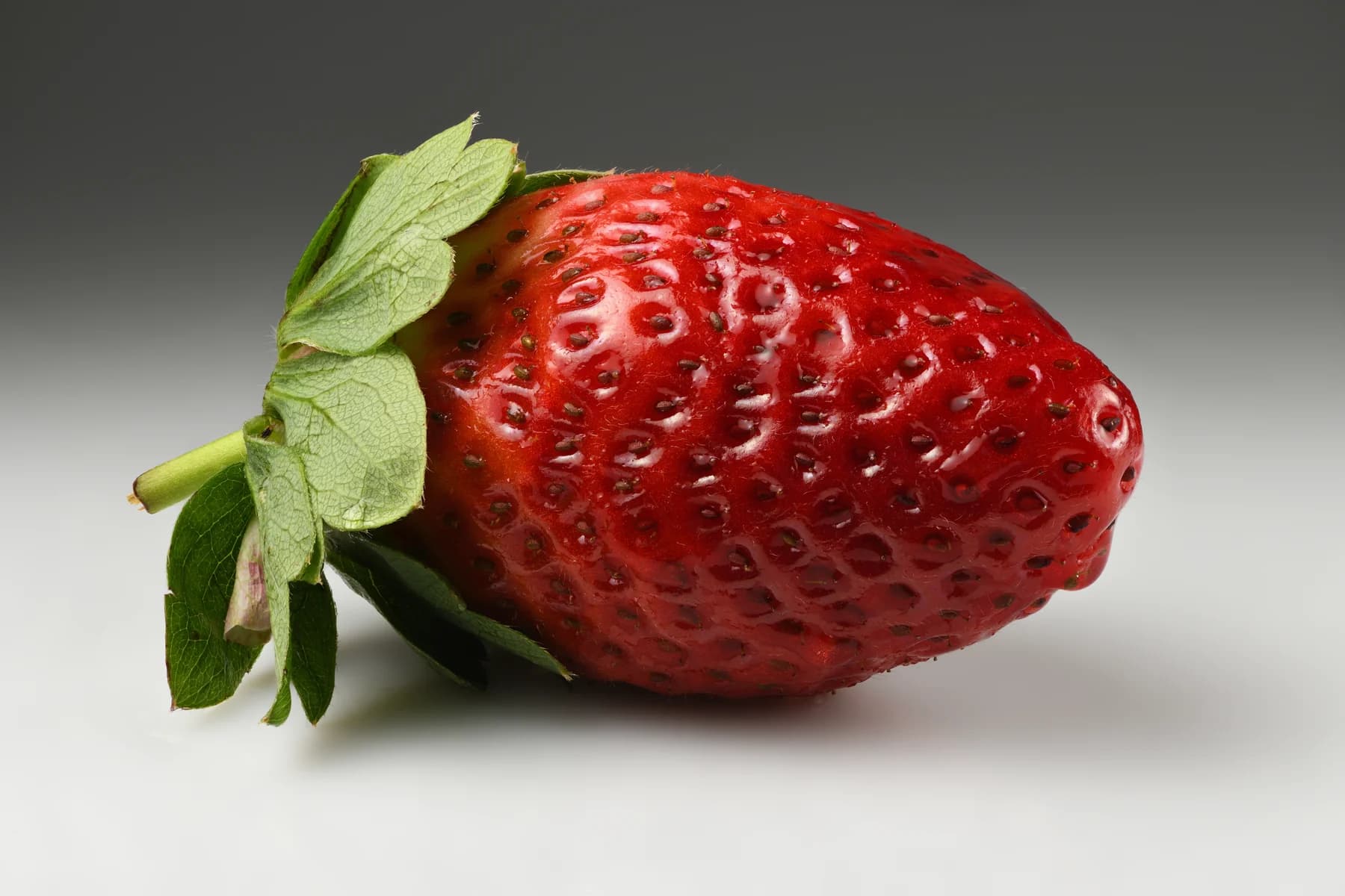 Ripe red strawberry with its green calyx